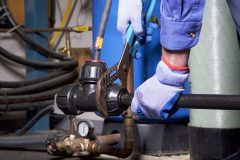 Gloved Hand Tightening Philmac Fitting with Wrench
