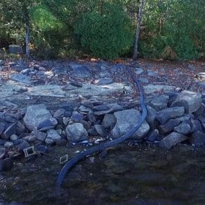 Water supply pipe on land to lake with stand at bottom of lake